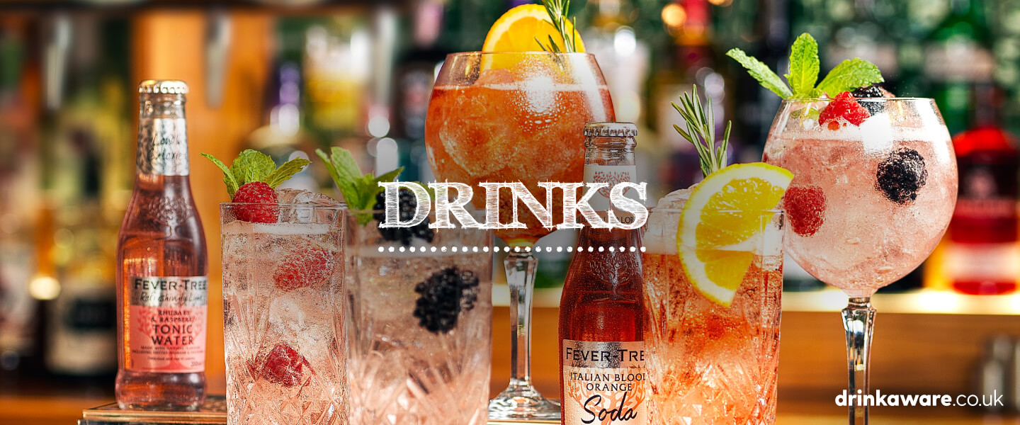 A collection of items from the Whitbread Inns drinks menu including fruit garnishes and bottles of orange soda and tonic water.